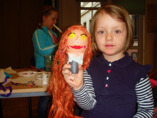 Dziewczynka pokazuje wykonaną przez siebie kukiełkę